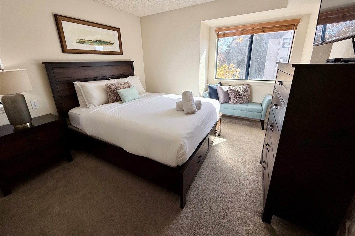 Queen bedroom with comfortable mattress, soft linens, smart tv with cable, dresser, walk in closet and lots of light.