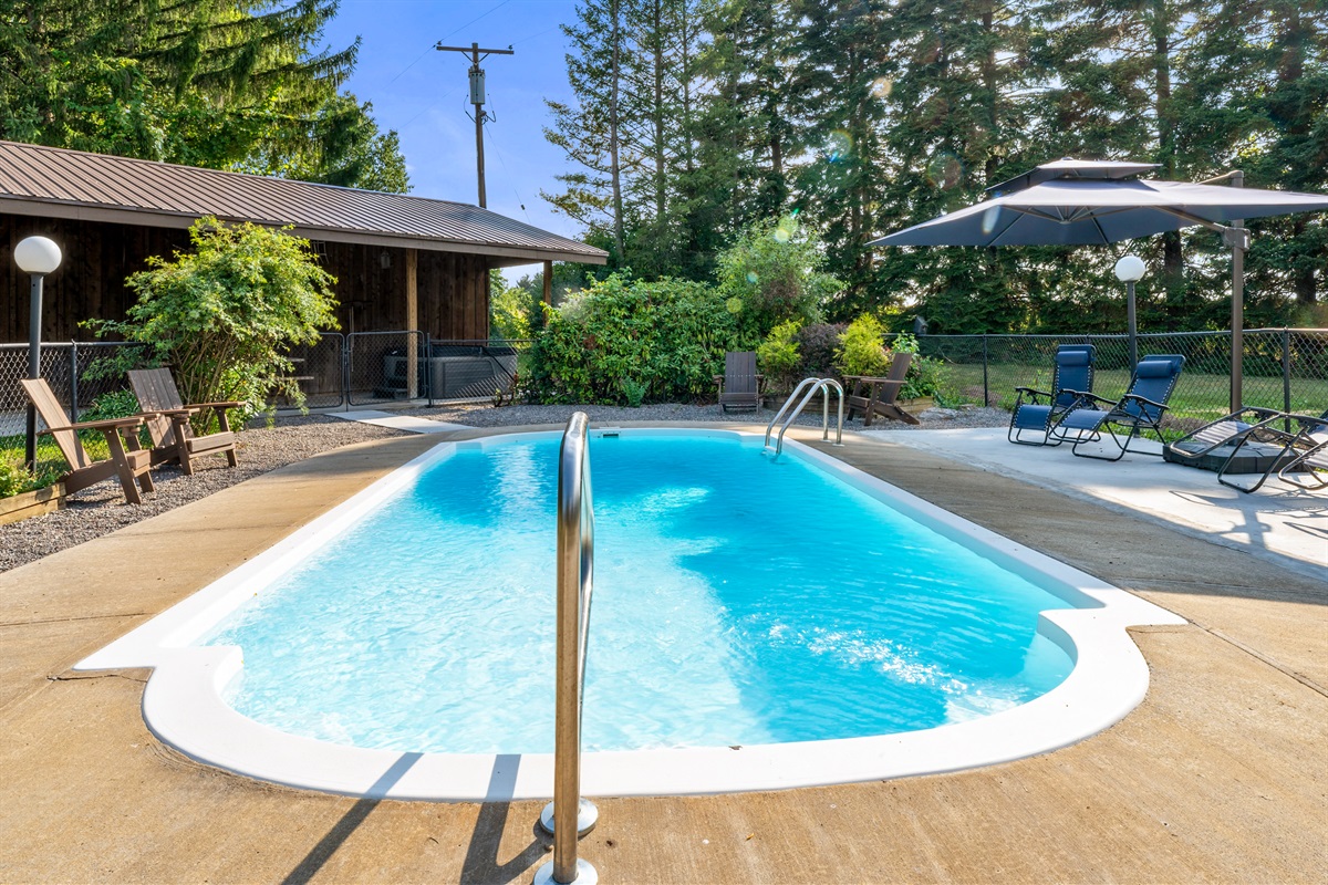 Relax and unwind by the sparkling private pool, surrounded by lush greenery and cozy seating for the perfect outdoor escape.