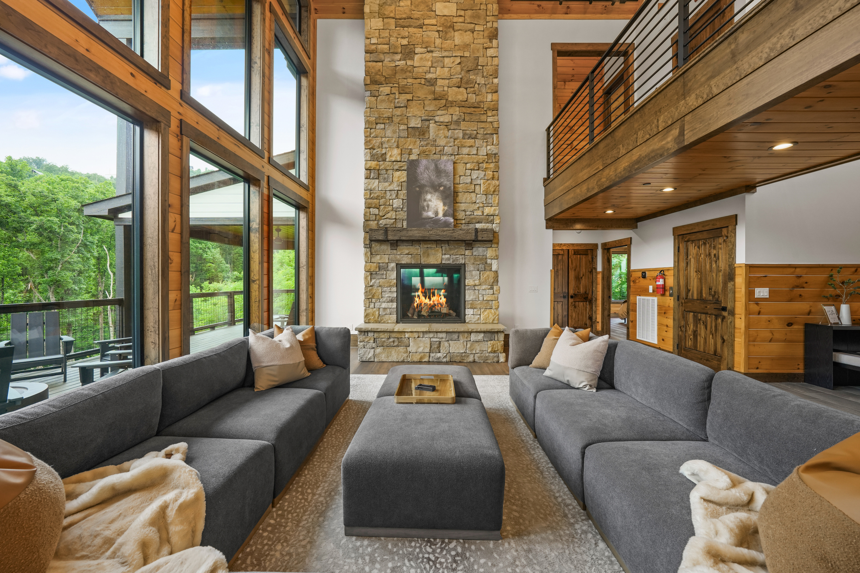 Gather beneath 30-foot vaulted ceilings surrounded by a wall of windows. Relax on the large sectional sofa beside the luxury fireplace with stunning floor-to-ceiling stone, creating a warm and unforgettable mountain lodge atmosphere.