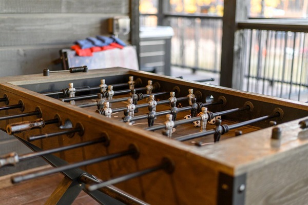 Enjoy exciting games on this vintage-style foosball table set on a spacious covered patio. A perfect spot for family fun and entertainment in a luxury cabin rental.