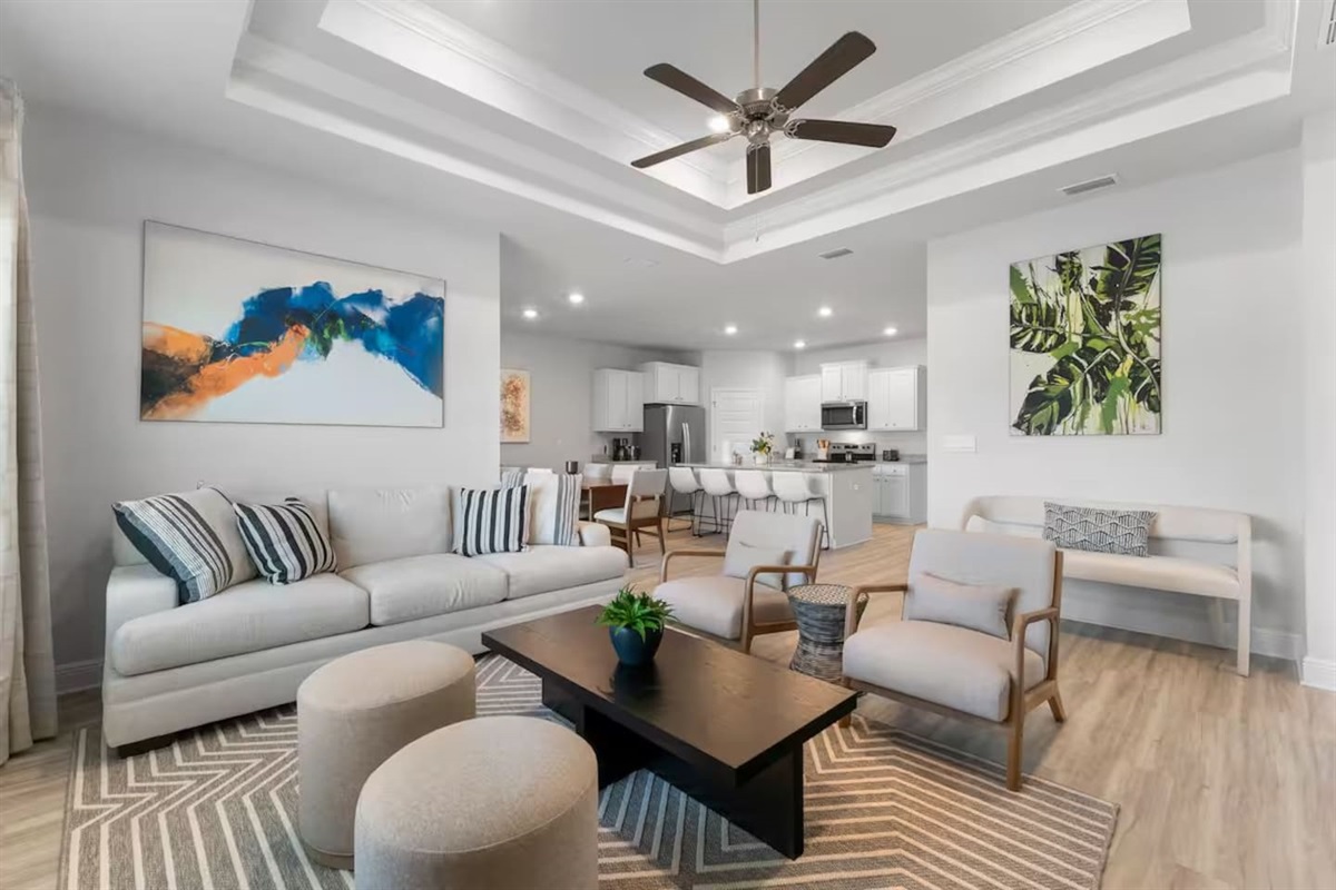 Spacious living area with ceiling fan, and natural light that creates a warm, welcoming atmosphere