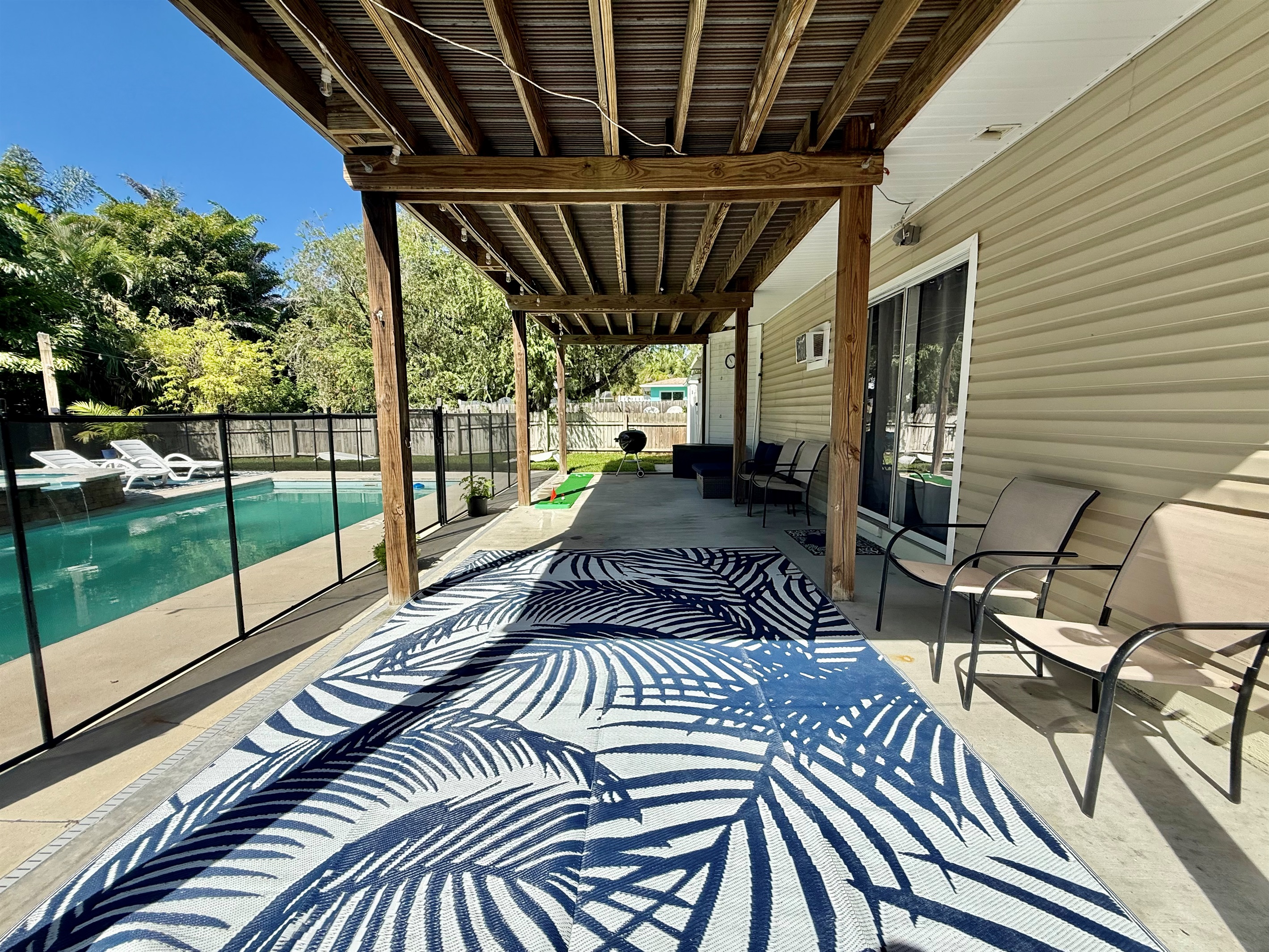 A spacious covered deck ideal for sipping drinks, reading, or watching the kids play in the pool.
