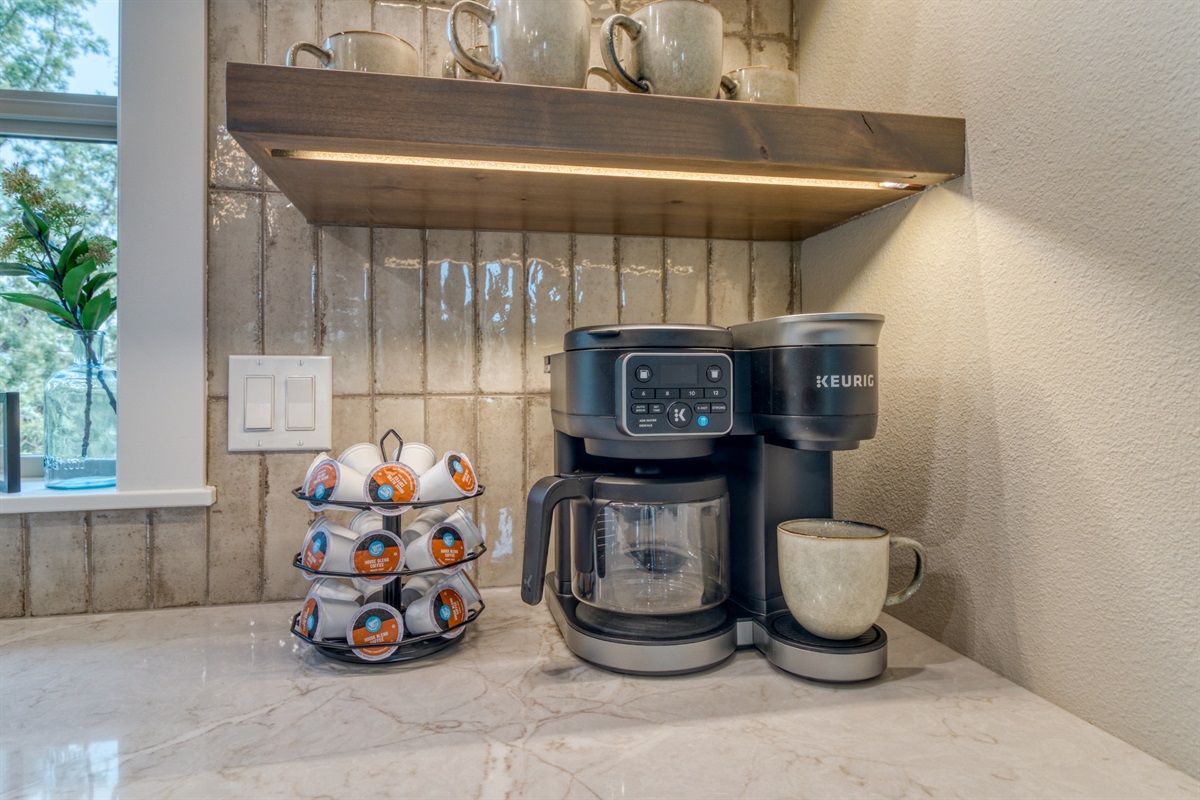 Corner coffee bar stocked with K-cups, creamers & sugars, and coffee filters.