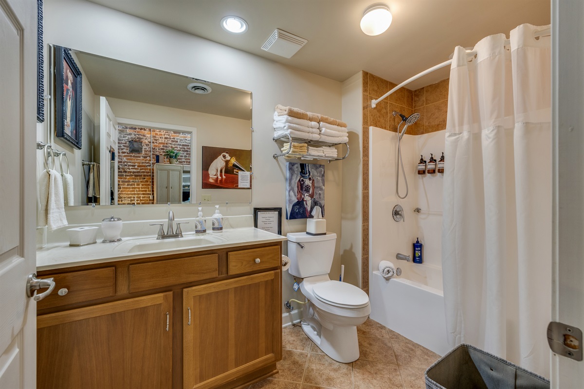 The bathroom features a full bath with a tub & shower. It's stocked it with shampoos, conditioner, body wash, and a basket of toiletries in case you forgot something.