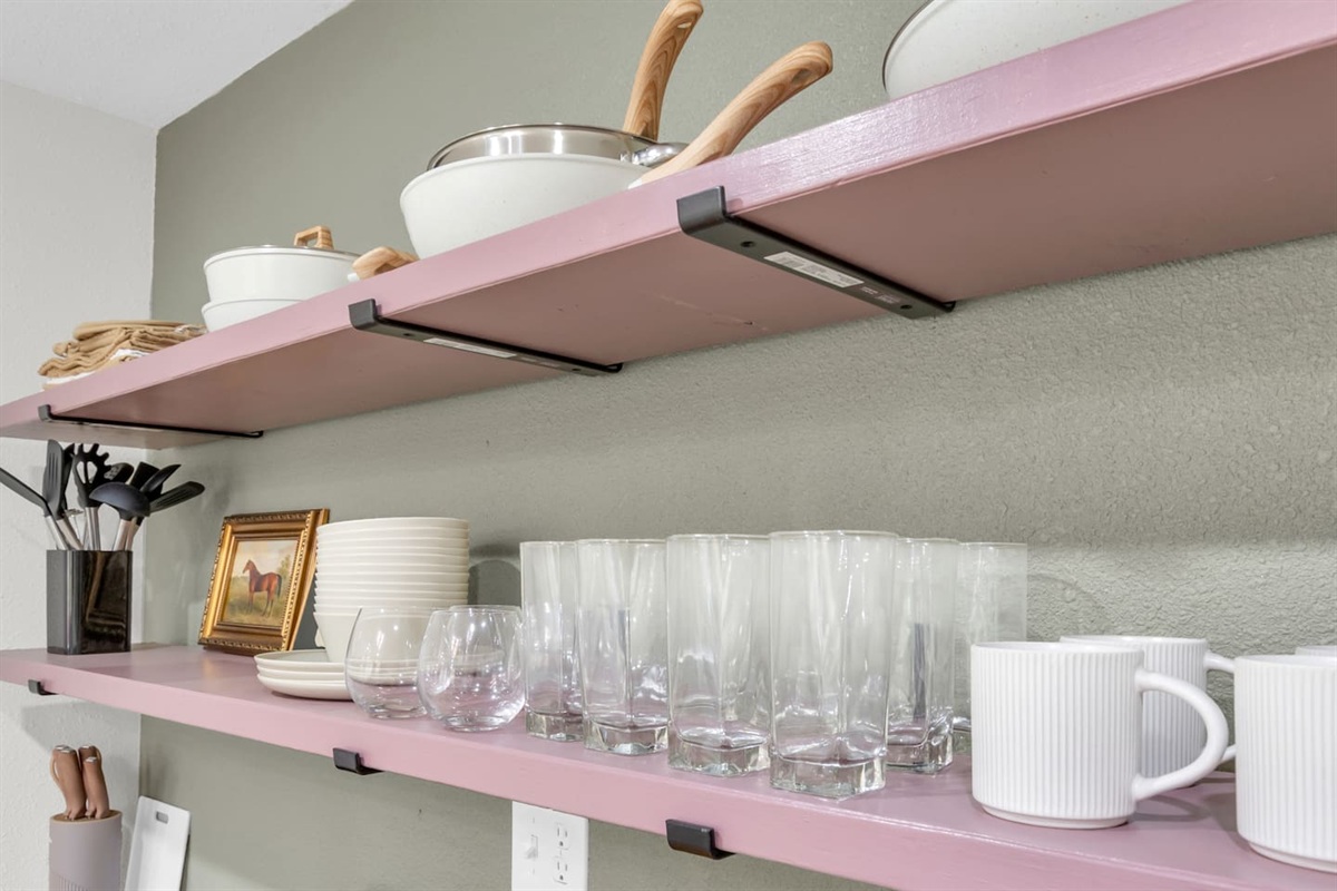 Everything you need for dining in; modern kitchen with electric range, oven, microwave, Keurig coffee maker, and fully supplied cookware and glassware.