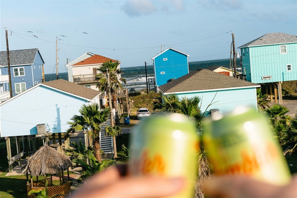 Cheers from the deck — the beach hangs just beyond. Start the week here