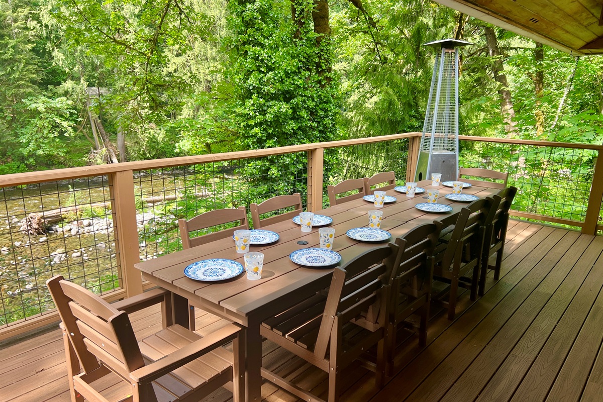 Bring everyone together to soak up the river, sun and surrounding trees on 3 large decks overlooking the Salmon River from the main house. This deck is just off the Great Room and has plenty of room to eat outside. There's also a covered grilling station.