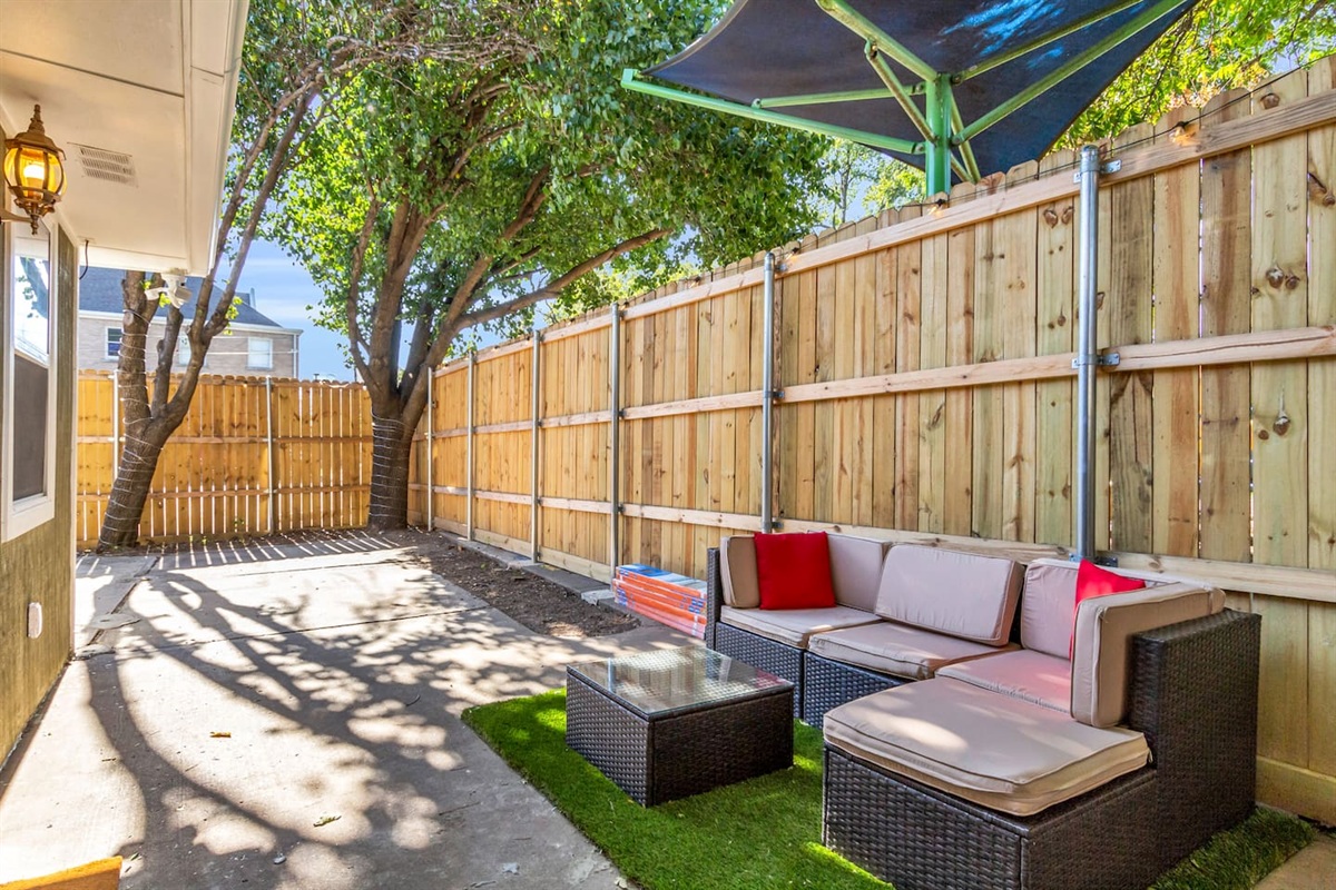 Relax on the shaded patio featuring comfortable seating and a coffee table—your private outdoor spot to unwind and enjoy the breeze.