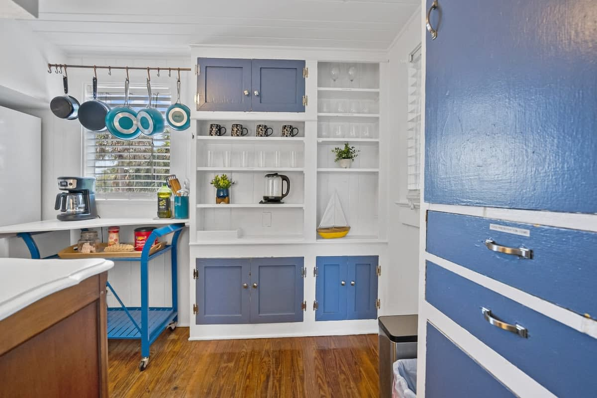 The little kitchen is set up for holiday food rather than feasts: fridge, microwave, kettle, blender and a drip coffee maker on open shelves. There is no stove or oven here, so plan on prep, reheating and easy slow mornings.