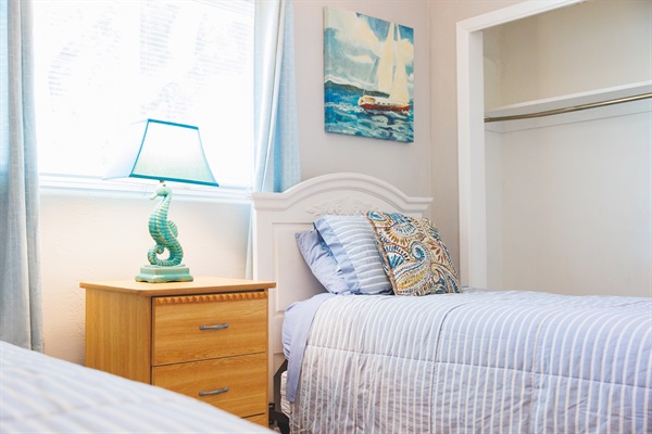 Sand Dollar Room with Two twin beds with linens, a dresser and two closets. 