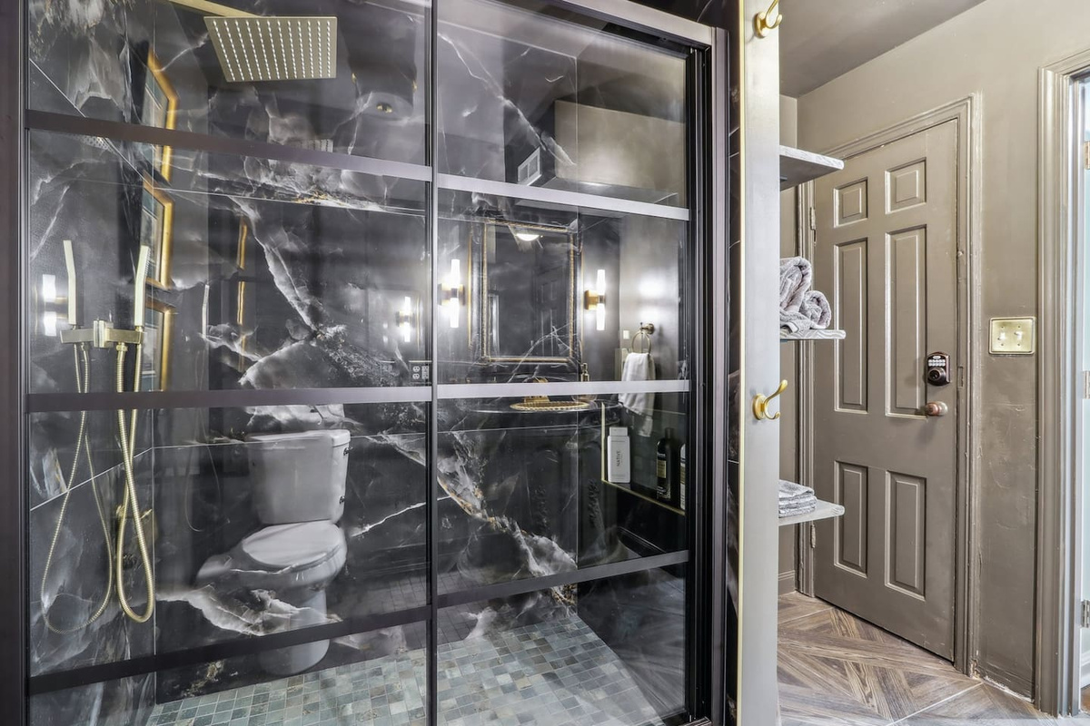 Freshen up in full bathroom 1, featuring a marble-look walk-in shower with a rainfall showerhead.