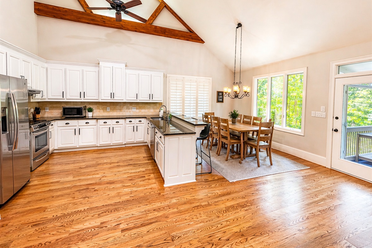 Bright open kitchen and dining area with vaulted ceilings, large island seating, and space for the whole group to gather.