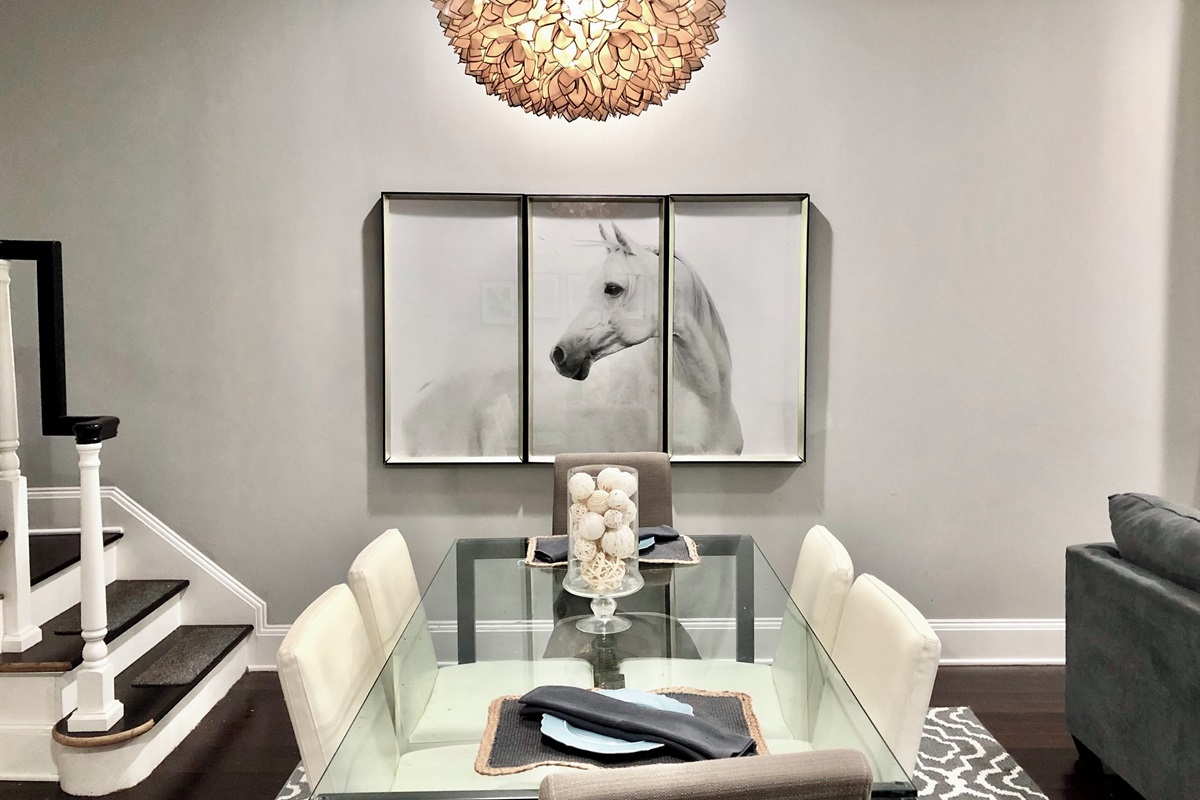 Gather around this sleek glass table for meals, games, or conversation—plush seating for six under a stunning designer light fixture.
