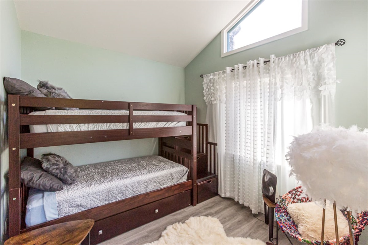 - Bright bedroom featuring sturdy wooden bunk beds with soft patterned bedding  
- High window paired with sheer curtains allows natural light to filter inside  
- Cozy corner space ideal for kids or extra guests seeking a comfortable stay  
