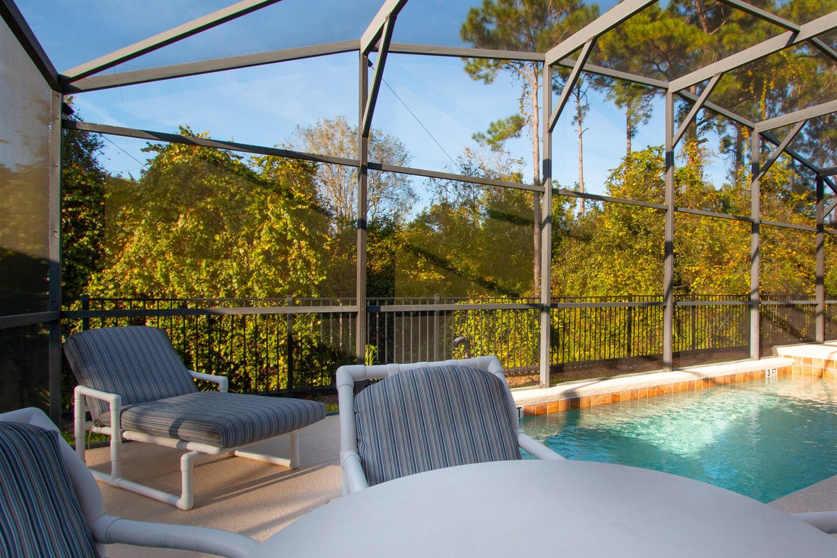 Loungers and table by the Private Screened Patio Pool.