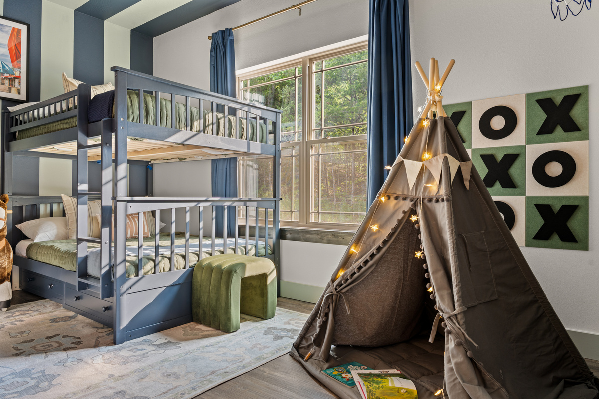 A light-up teepee and giant XOXO board turn the bunk room into a nightly hideout for the kids.