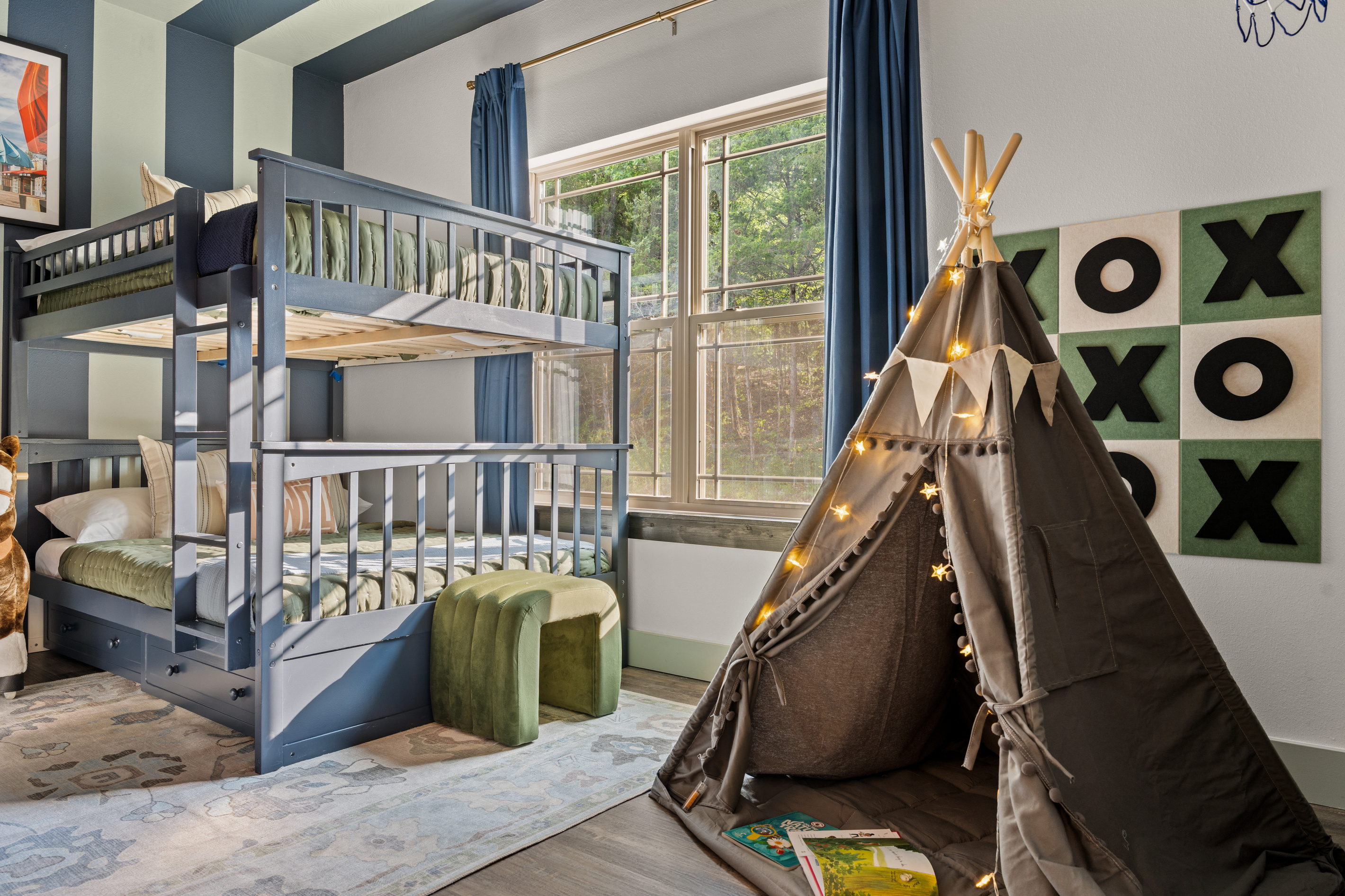 A light-up teepee and giant XOXO board turn the bunk room into a nightly hideout for the kids.