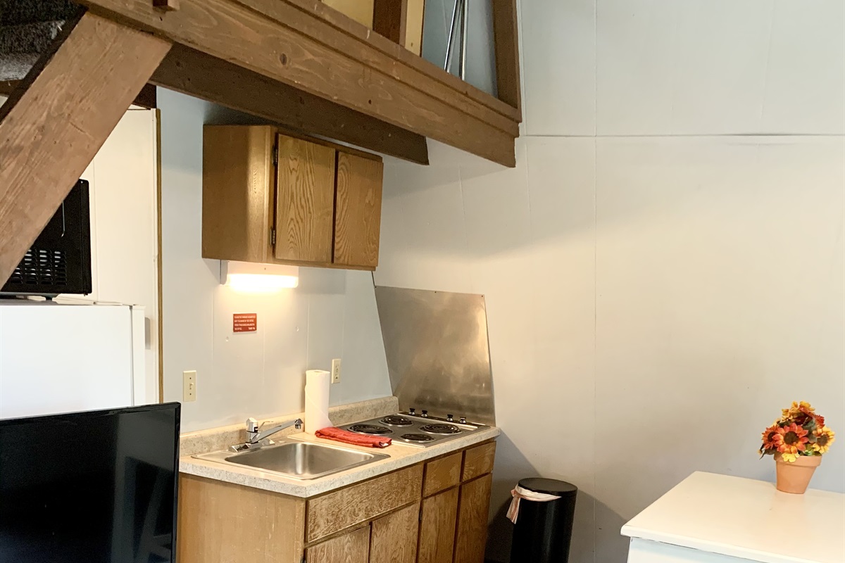 Kitchenette with stove top, fridge, and microwave