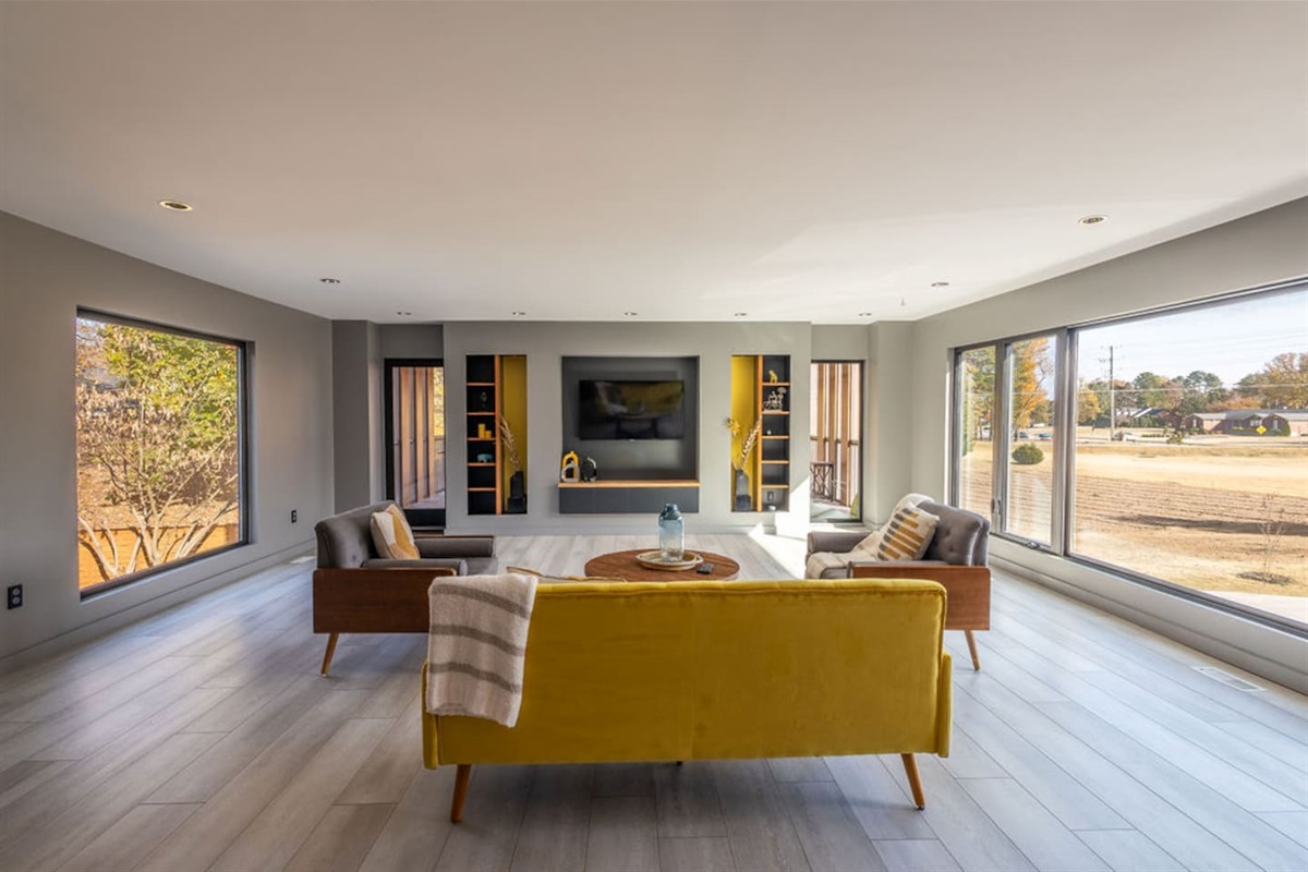 Spacious living room with large windows offering a beautiful view of the outdoors, bringing natural light and scenic beauty into the heart of the home.