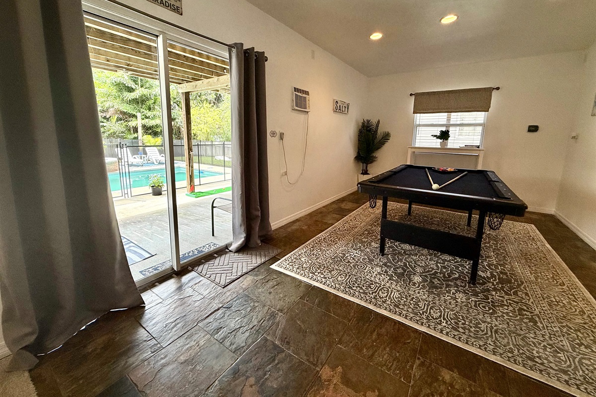 Multi-purpose space featuring a full bed and pool table for ultimate fun.