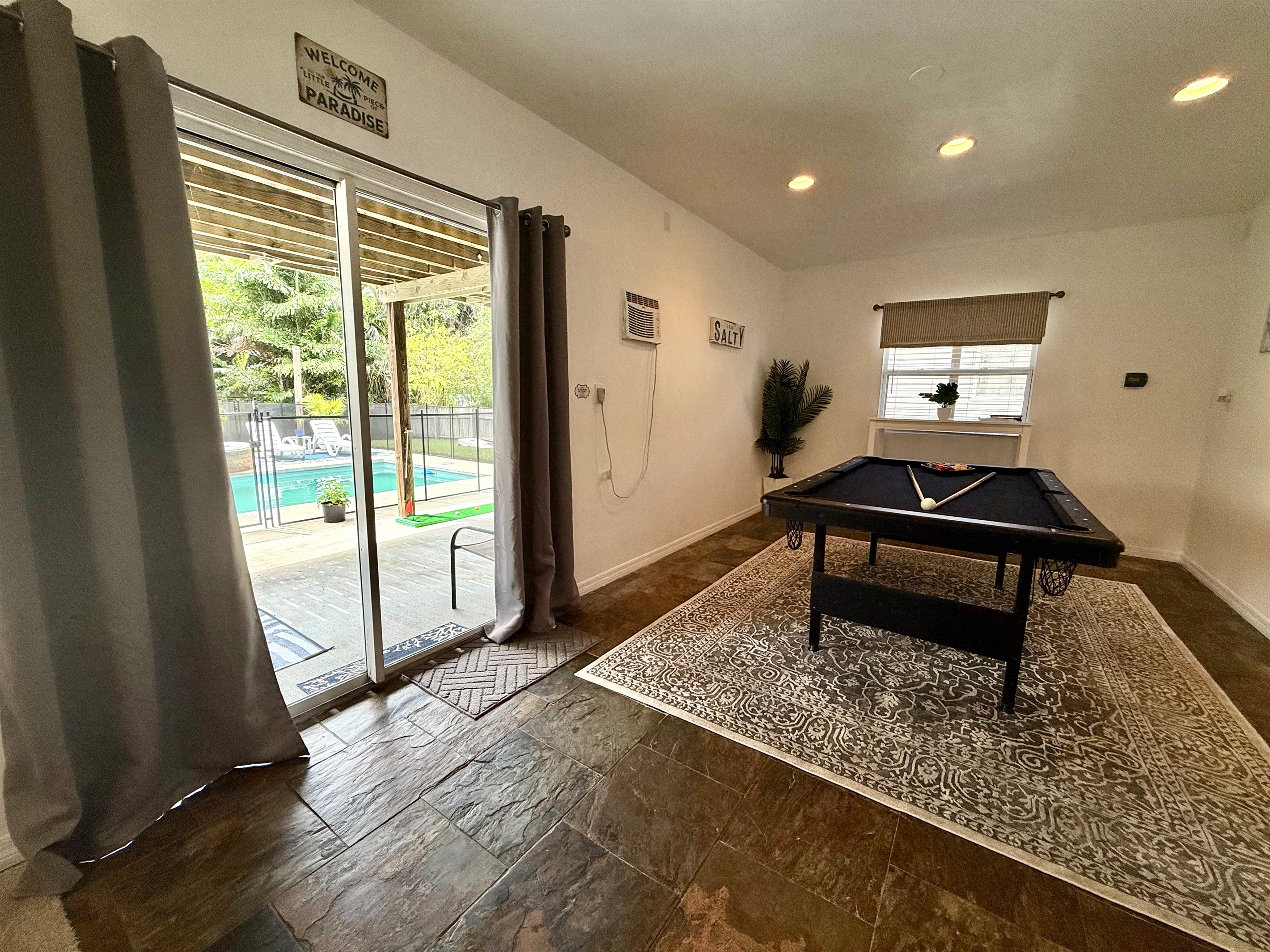 Multi-purpose space featuring a full bed and pool table for ultimate fun.