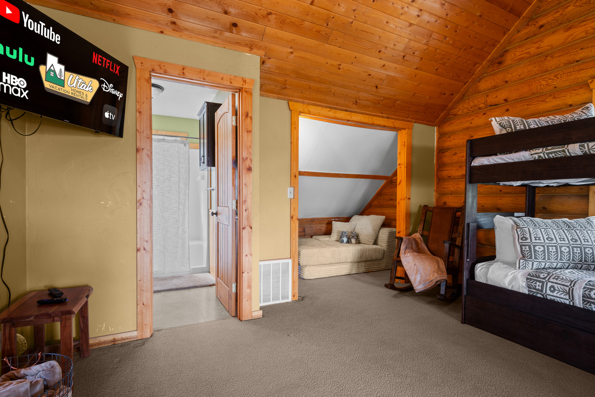 Large loft sleeping area featuring bunk beds, TV, and easy access to the upstairs bathroom.