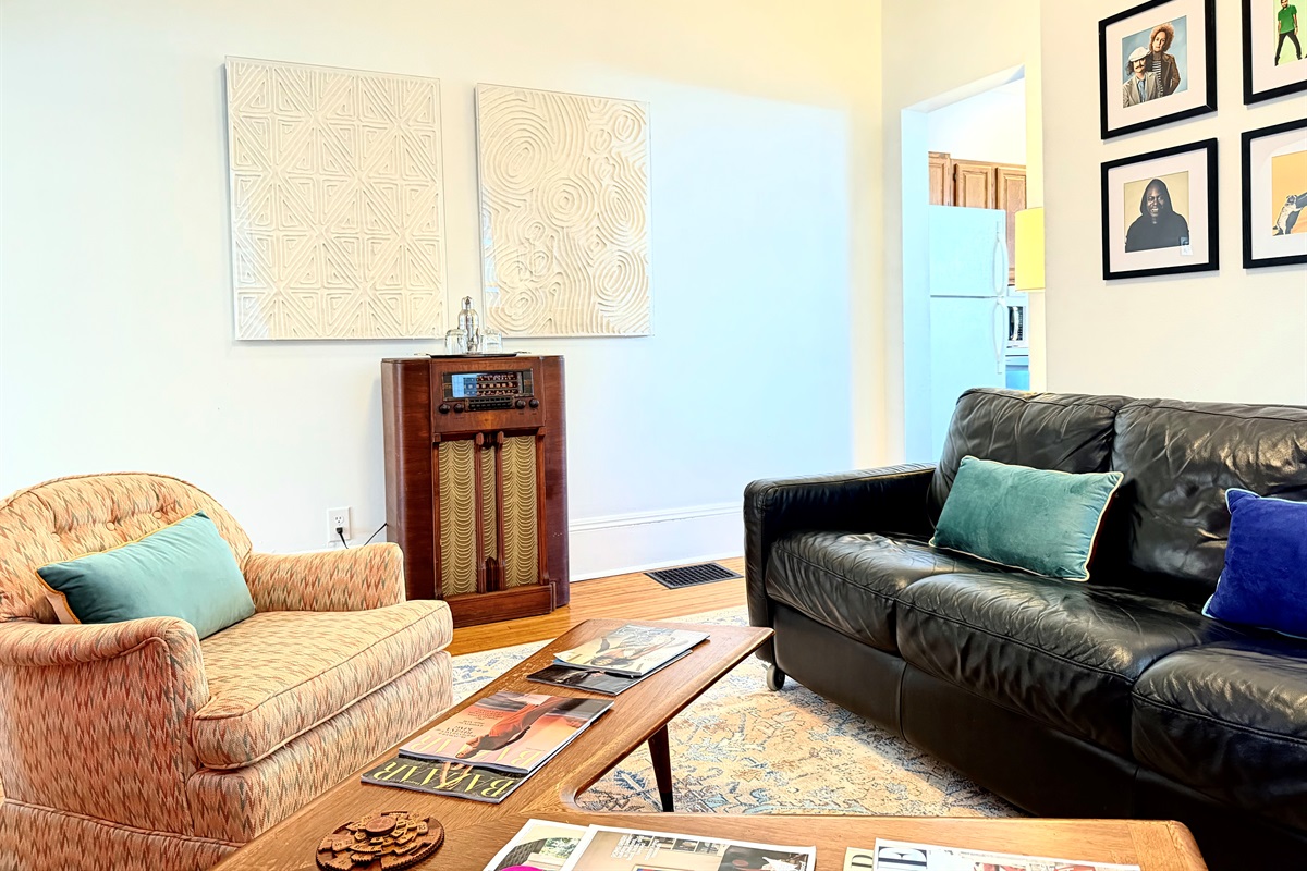 Anchored by a mid-century boomerang coffee table, a comfortable lounge, and a beautifully restored vintage stereo console — a space that invites you to sit down, slow the pace, and linger a while, just like the old days.