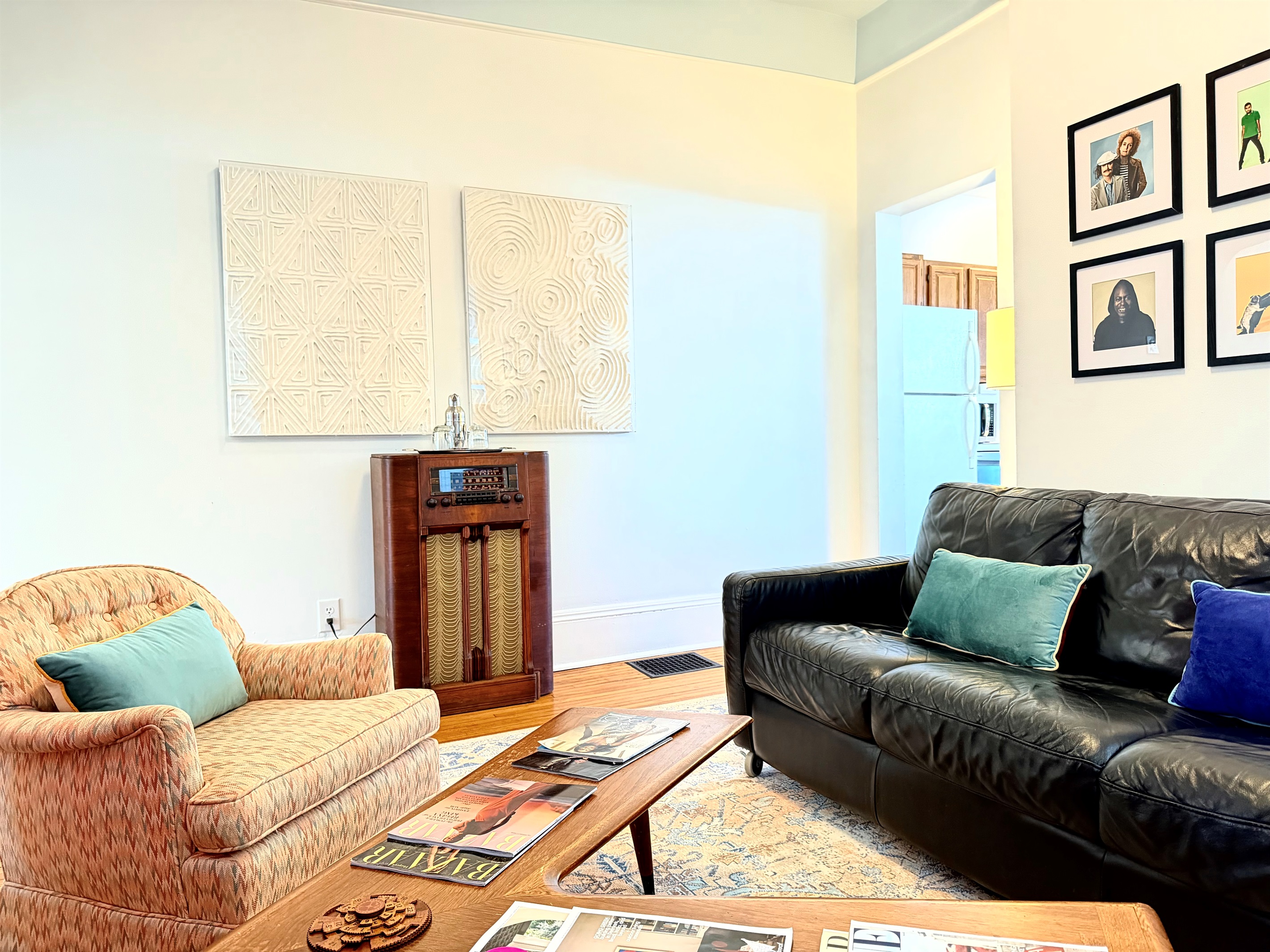 Anchored by a mid-century boomerang coffee table, a comfortable lounge, and a beautifully restored vintage stereo console — a space that invites you to sit down, slow the pace, and linger a while, just like the old days.