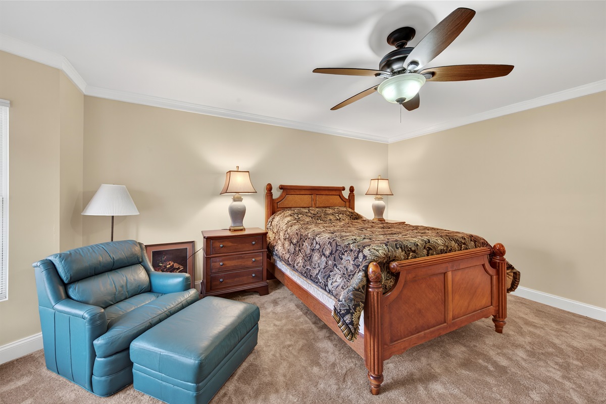 Cozy bedroom with a comfortable bed and a quiet reading corner.