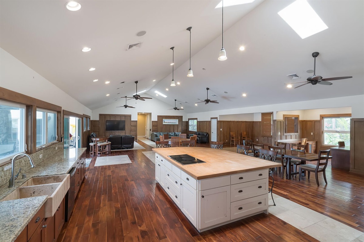 Spacious kitchen with polished dark wood floors, granite countertops, and abundant natural light