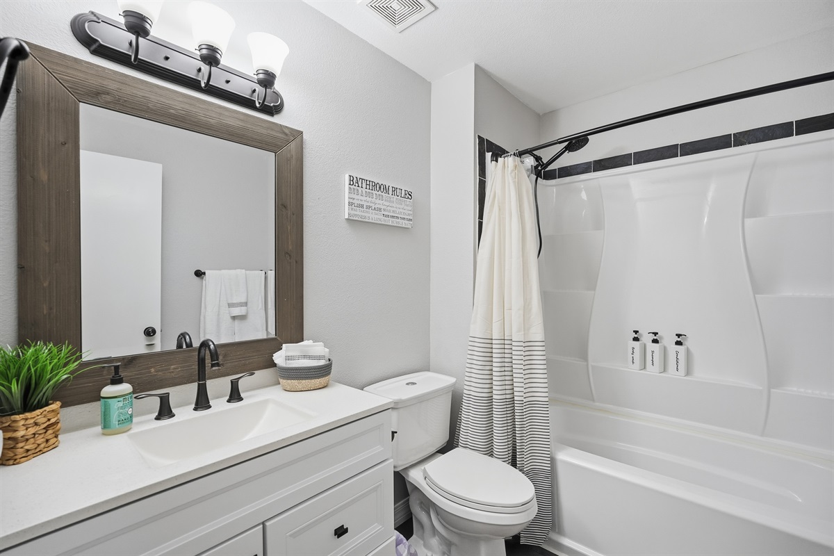 second bathroom with tub and shower, warm tones, fresh linens, and everyday comforts.