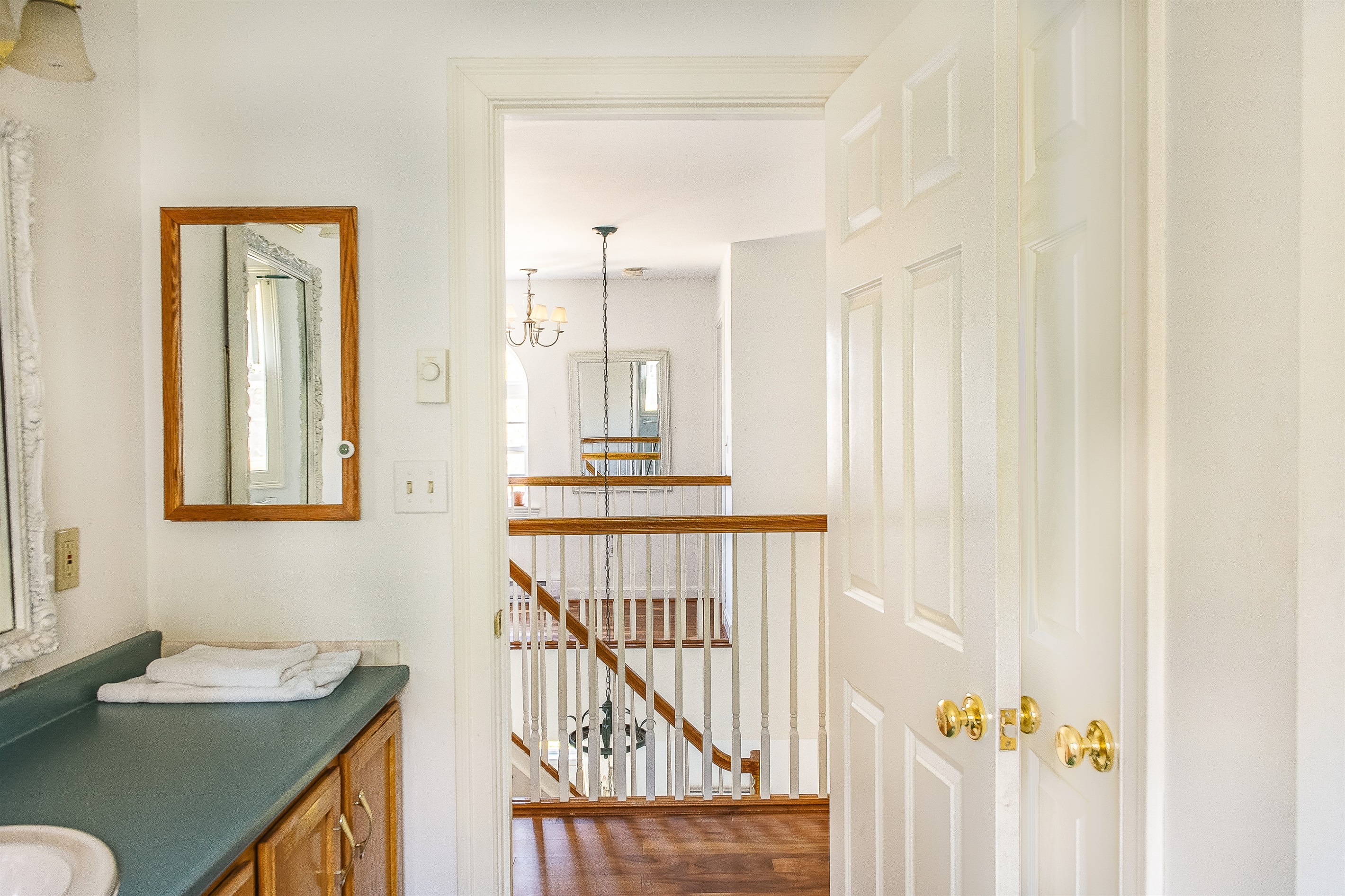 View from the full guest bathroom looking back toward the airy second-floor landing. This layout ensures easy access for those staying in the guest bedrooms, maintaining a bright and open feel throughout the upper level of the home.