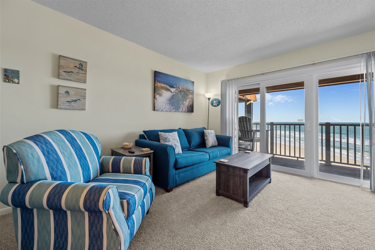 Spacious coastal living area with comfortable seating and sweeping ocean views to enjoy together!
