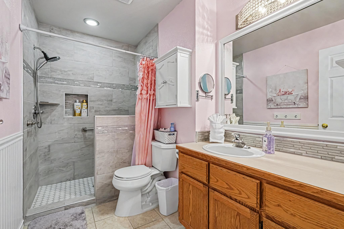 This private ensuite bathroom is conveniently located off the primary bedroom and offers the added benefit of being handicap accessible, providing comfort, convenience, and accessibility and accessibility for all guests. 