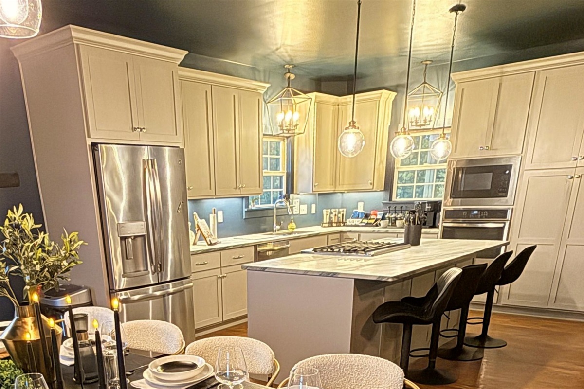 A chef-inspired kitchen designed for connection — with stone countertops, artisan lighting, and premium appliances ideal for tastings, chef dinners, and effortless entertaining.