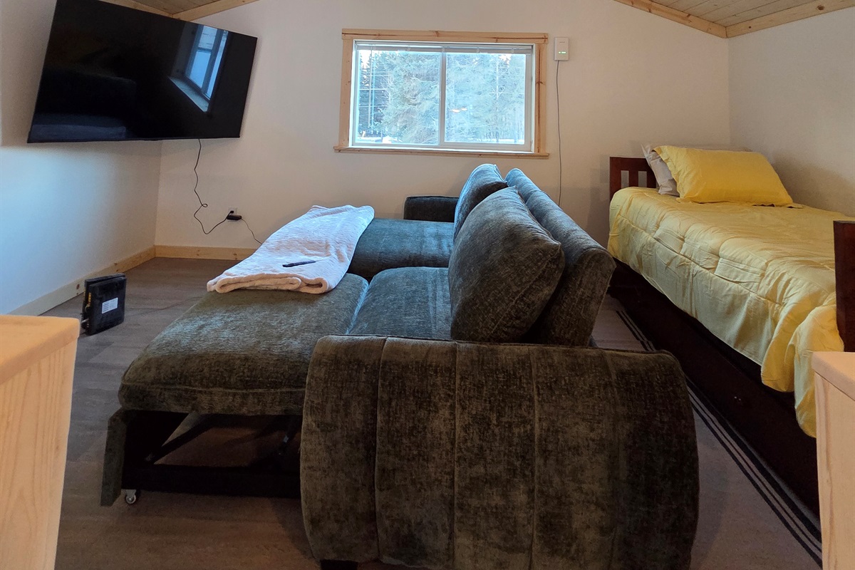 Loft area includes large swivel chair, sofa sleeper, and additional bed (twin bed with trundle bed)