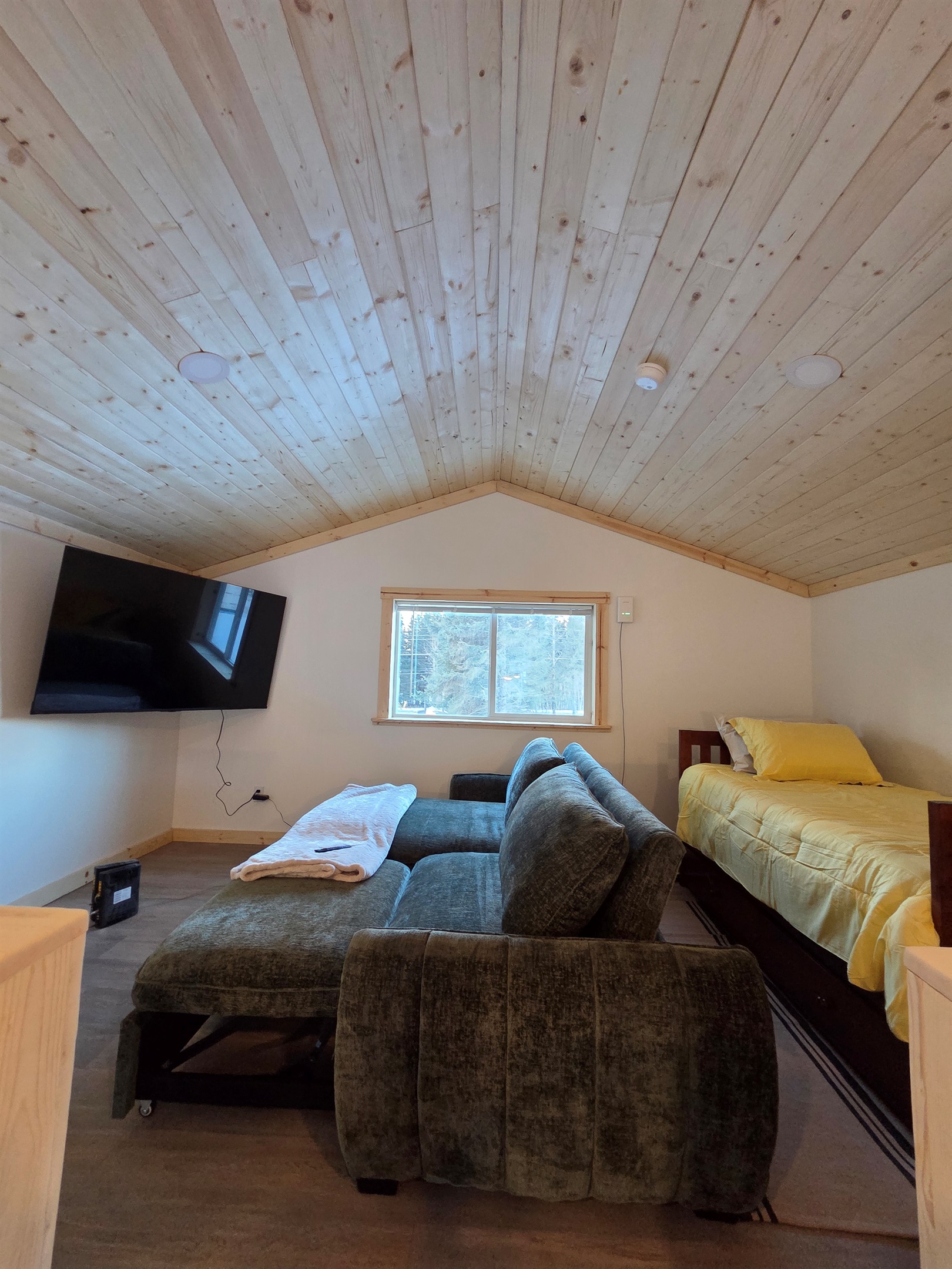 Loft area includes large swivel chair, sofa sleeper, and additional bed (twin bed with trundle bed)