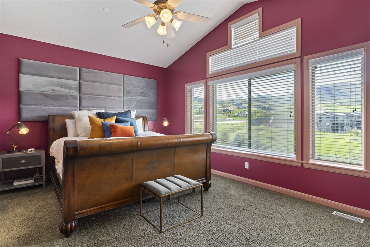 The primary suite offers a luxurious escape with a king bed, vaulted ceilings, and expansive windows that frame breathtaking mountain views.