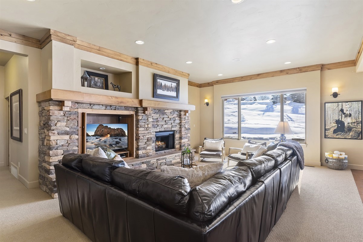 A spacious, lodge-style living room with vaulted ceilings and a stunning stone fireplace—perfect for gathering in comfort.