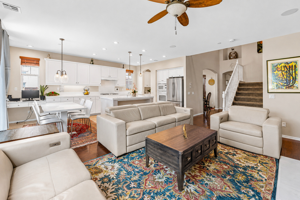 Open living room with comfy seating, a full kitchen nearby, and space for everyone to hang out.
