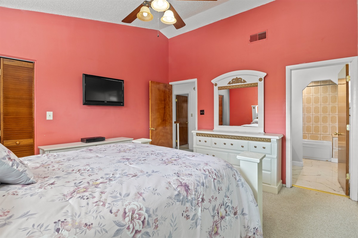 Master bedroom. Closet. TV. Door shows entrance to ensuite full bathroom.