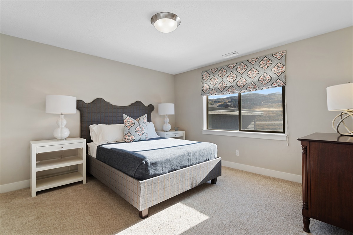 Comfortable upstairs bedroom with queen bed and mountain views.