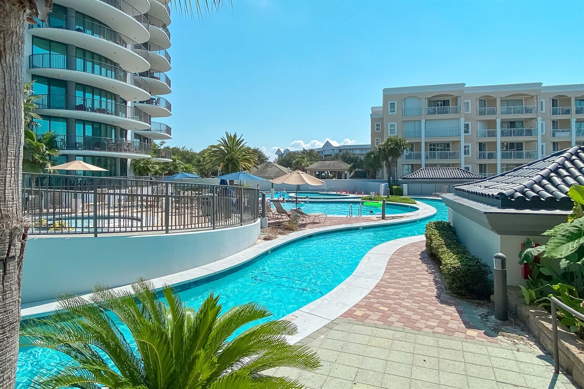 Dive into paradise! This stunning photo captures the resort-style lazy river, surrounded by lush tropical landscaping at the beautiful Lighthouse on the Bay II