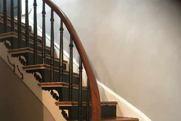 Original wood spiral stairs leading to private suite