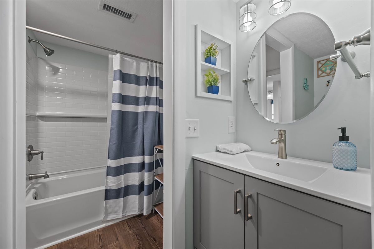 Bright vanity space with modern lighting and a sleek, coastal feel