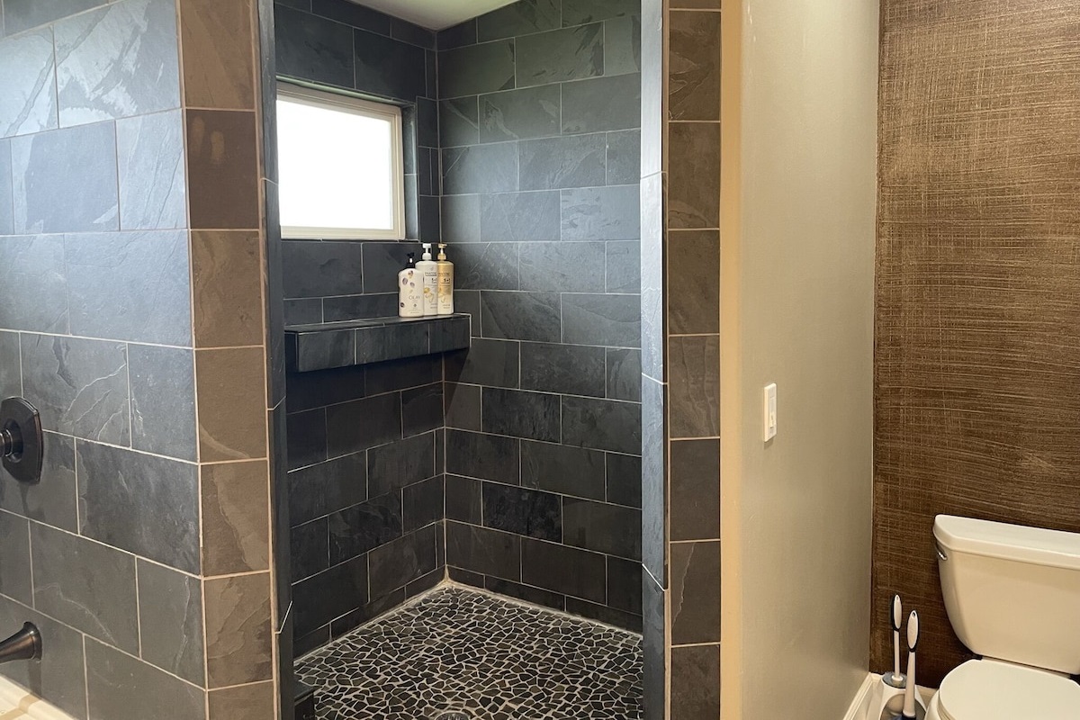 Custom walk-in primary shower with river rock tile.