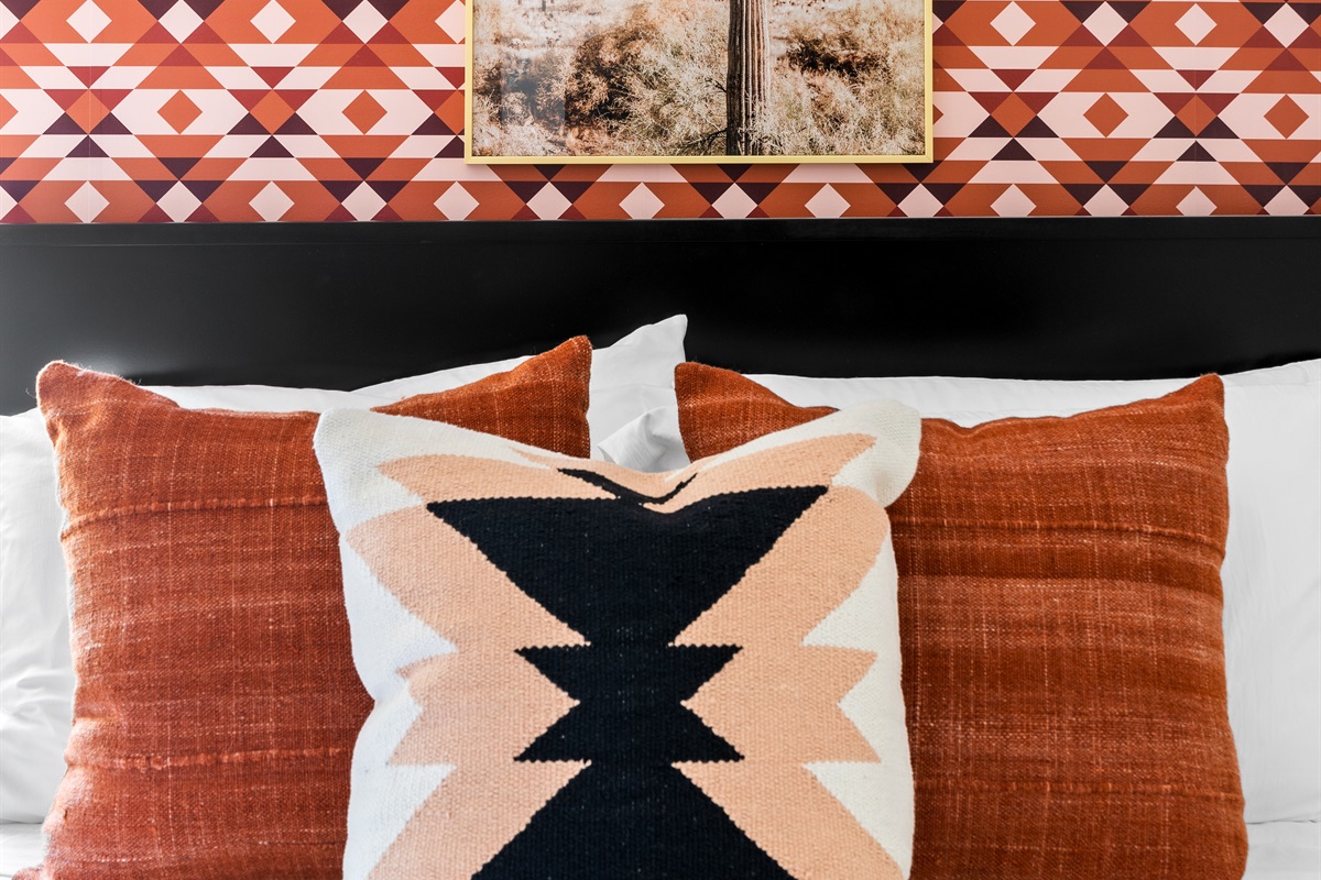 Stylish bedroom with bold patterns and cozy pillows, perfect for a relaxing retreat.