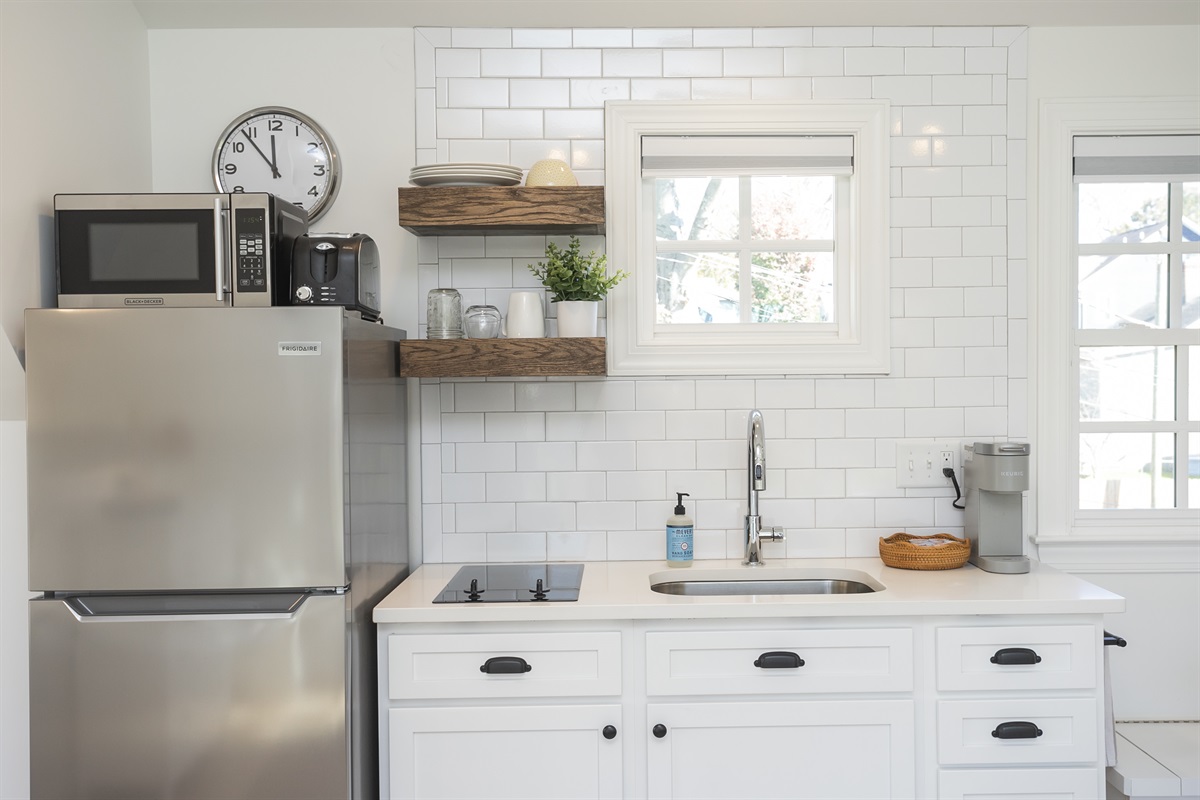 Kitchen includes a stovetop, microwave, toaster, and coffee maker