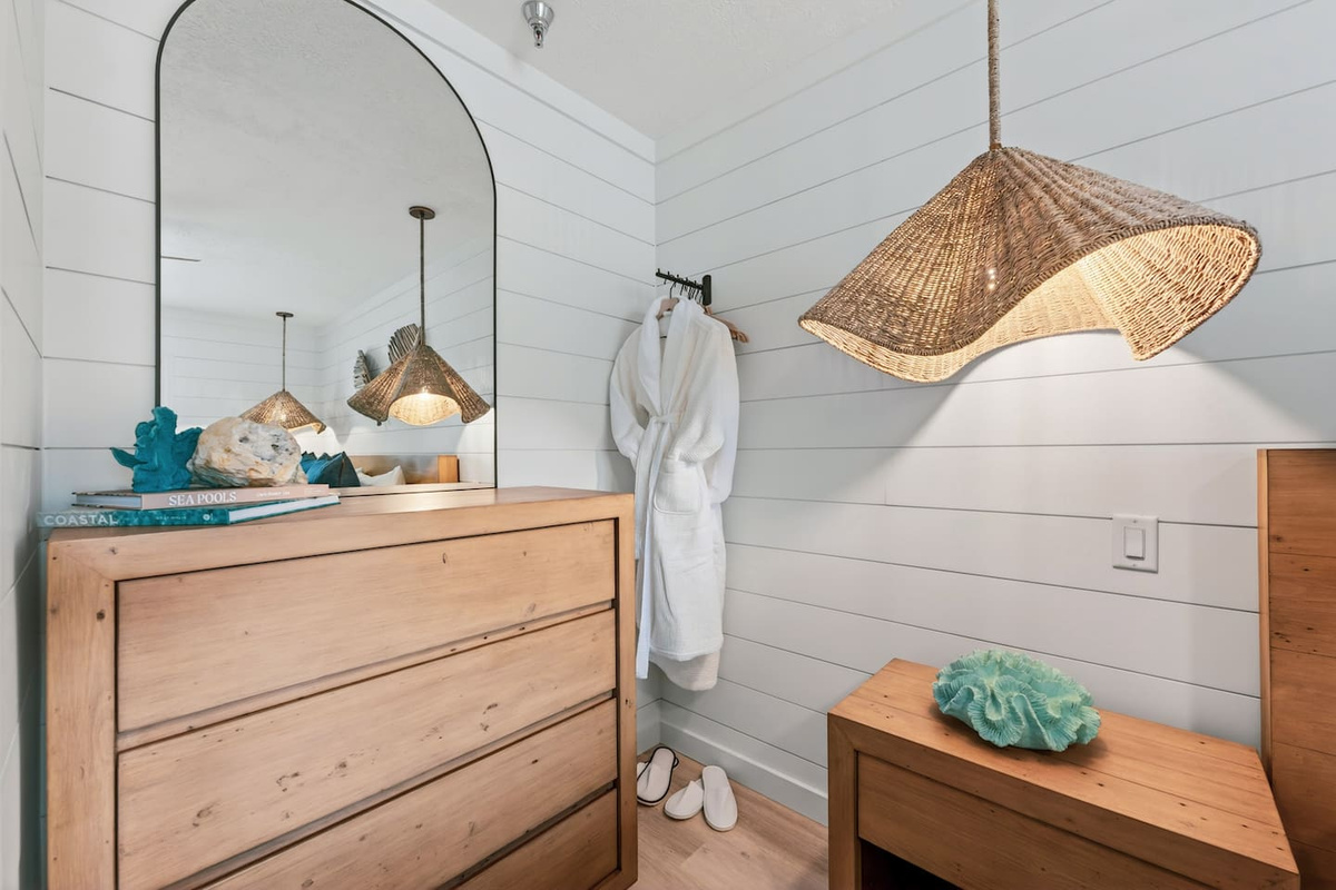 Coastal bedroom details at El Secreto Azul, with bathrobes, rattan lighting and shiplap finishes.