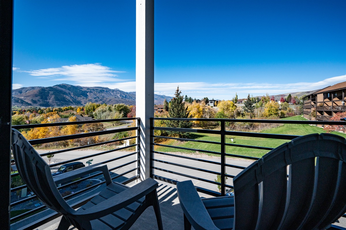 Private balcony off Bedroom 1 with seating for two and scenic views.
